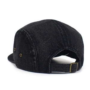 Detail of black denim 5-panel camper hat with adjustable strap and metallic buckle
