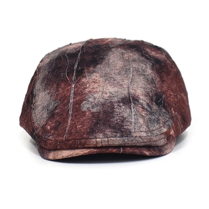 Close-up of vintage brown marbled texture fabric and stitching on a flat cap
