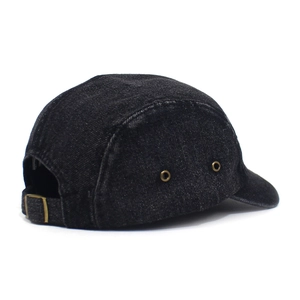 Detail view of denim camper hat showing metal eyelets and adjustable buckle strap