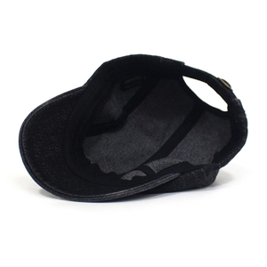 Detailed interior of the black denim flat cap showing inner tape and washed fabric texture
