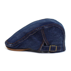 Detail view of denim flat cap with brown stitching and metallic side adjustment buckle