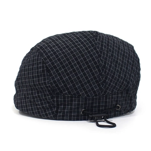 Detail of the adjustable black drawcord and buckle on a classic plaid beret hat