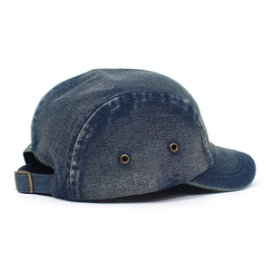 Detail of dark blue denim camper hat with metal eyelets and adjustable rear strap buckle