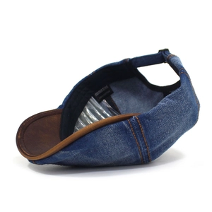 Detail of washed denim octagonal hat with orange stitching and leather brim edging
