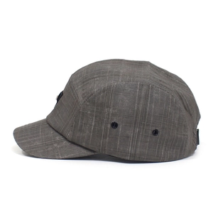 Detail view of the gray grid pattern fabric and metal air vents on the baseball cap