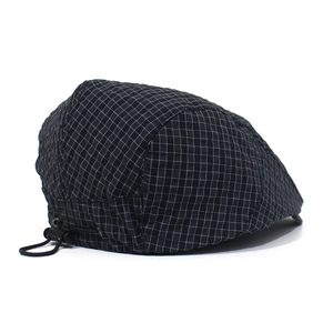 Detail of adjustable toggle and fine checkered texture on quick-dry flat cap
