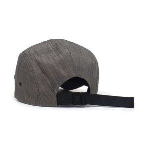 Detail view of dark grey five-panel cap with black strapback closure and metal eyelet