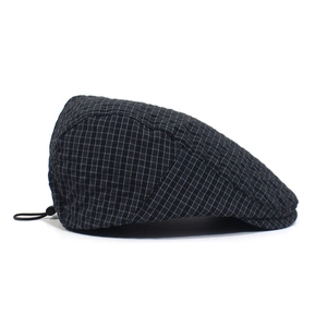Detail of classic plaid newsboy cap with adjustable drawstring and woven texture pattern