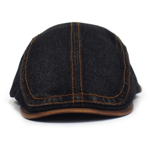Detail of denim ivy cap featuring orange contrast stitching and a brown leather brim