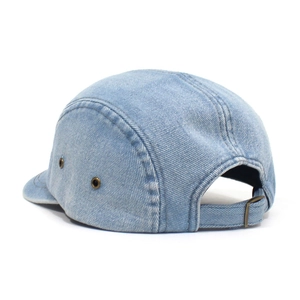 Detail view of light blue denim 5-panel cap featuring metal eyelets and adjustable strap