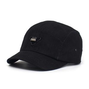 Close-up of black cotton camp cap featuring a triangular metal logo and metal eyelets