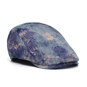 Detail of vintage crinkled newsboy cap with blue and beige ink wash texture