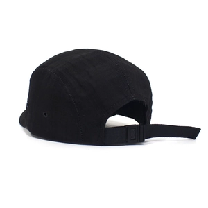 Detail of adjustable nylon back strap and plastic buckle on black 5-panel baseball cap