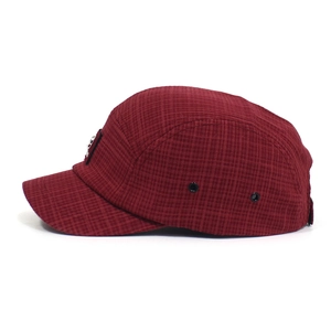 Detail van bordeauxrode 5-panel pet met micro-grid textuur en metalen oogjes