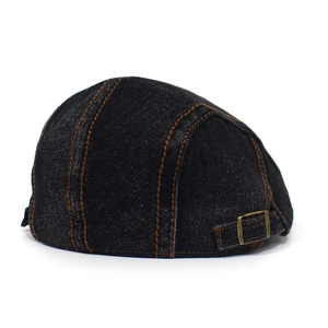 Detail of dark denim beret with orange contrast stitching and adjustable bronze buckle