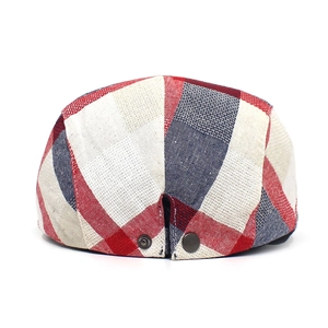 Detail of red and navy plaid fabric and metal buckle on back of the beret cap