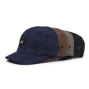 Detail of adjustable 5-panel baseball caps with metal logo plate and grid texture fabric