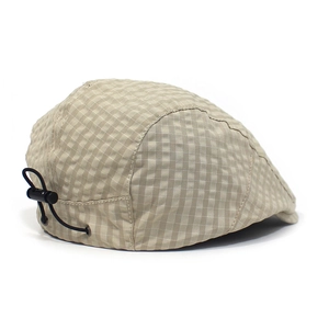Detail view of beige plaid beret with adjustable black elastic drawstring and cord lock