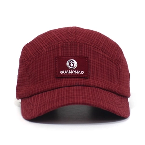 Detail van bordeauxrode 5-panel baseballpet met GUANCHAO-patch en gestructureerde katoenstof