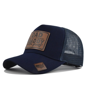 Detailed view of navy blue trucker hat with DADDY leather patch and mesh back