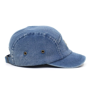 Detail view of washed blue denim 5-panel hat showing metal eyelets and fabric texture