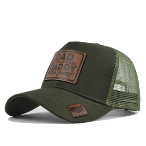 Detail of dark green trucker hat featuring a brown leather patch and mesh back design