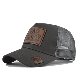 Detail of grey mesh trucker hat featuring DAD leather patch and breathable mesh structure