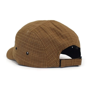 Detailweergave van bruine geruite 5-panel pet met metalen oogjes en verstelbare band