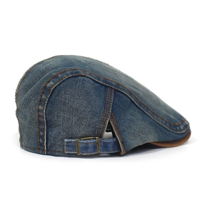 Close-up of vintage denim flat cap featuring orange stitching and adjustable metal buckle