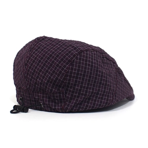 Close-up of adjustable elastic drawstring and plastic toggle on purple plaid beret cap