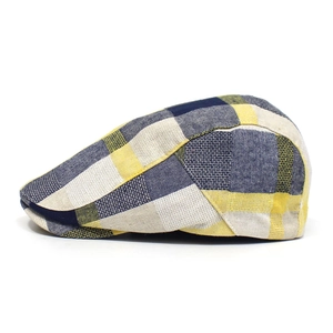 Detail view of navy blue and yellow plaid flat cap with vintage British textured fabric