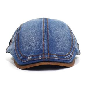 Detail showing deep blue washed denim fabric with brown leather brim and contrast stitching