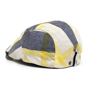 Close-up of beige and navy plaid fabric texture and metal side buckle on the flat cap