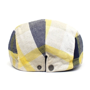 Detail of colorful plaid flat cap showing metal buckle and coarse weave fabric texture