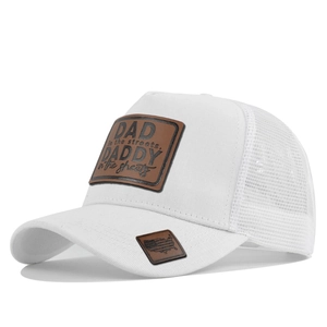 Detailed close-up of white trucker hat with leather patch and breathable mesh back