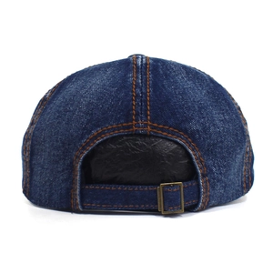 Detail view of denim octagonal hat featuring orange stitching and metal adjustment buckle