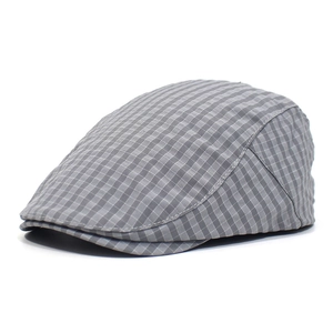 Detailed close-up of grey plaid newsboy cap showing fine stitching and classic fabric texture