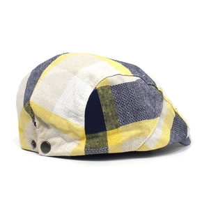 Detail view of colorful plaid beret with metallic buckle and woven cotton fabric