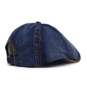 Detail of washed denim octagonal hat showing orange stitching and metal back buckle