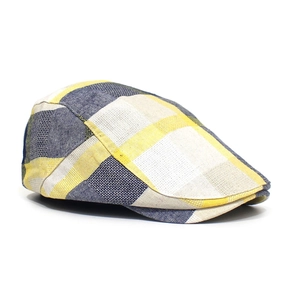 Detail of yellow and navy plaid flat cap showing textured wool fabric and peak structure