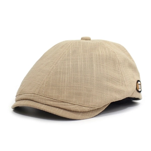 Detailansicht der beige karierten Baskenmütze mit rundem m-Logo auf der seitlichen Textur