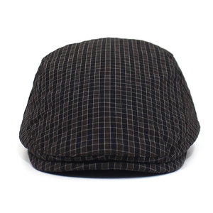 Detail showing the brown checkered fabric texture and fine stitching on the beret hat