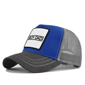 Détail du patch BOY DAD et coutures ondulées sur une casquette trucker bleu et gris