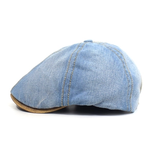 Detail of washed denim octagonal hat featuring contrast yellow stitching and brown leather brim