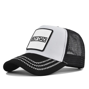 Détail du patch BOY DAD sur casquette trucker en mesh avec coutures ondulées sur la visière