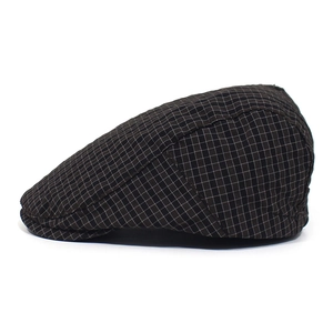 Detailed side view of vintage dark brown plaid ivy cap with fine textured grid patterns