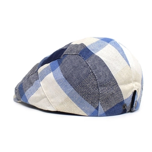 Detail view of the blue checkered flat cap featuring a metal buckle and breathable eyelets