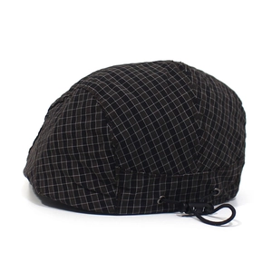 Detail view of the adjustable elastic drawstring and buckle on this plaid beret cap