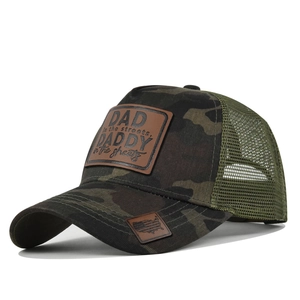 Detail of forest camo trucker hat with DAD leather patch and green mesh back