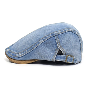 Detail of adjustable metal buckle and vintage denim texture on a flat cap